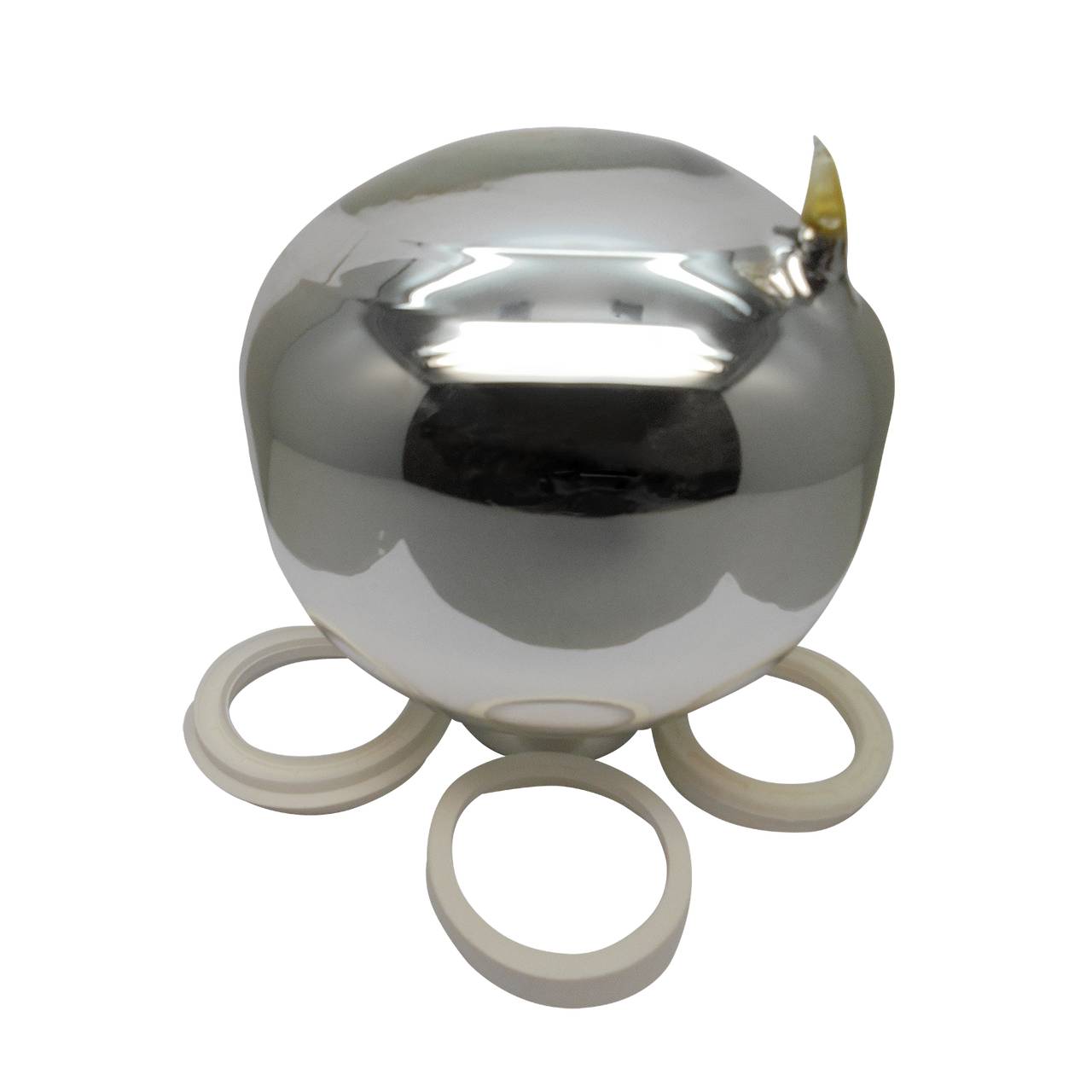 Das Bild zeigt einen silbernen, spiegelnden Globus, der ein wenig an einen Tropfen erinnert, auf einem runden Sockel. Um den Sockel herum liegen vier weiße Ringe. Die Oberfläche des Globus ist glänzend und reflektiert das Licht stark.