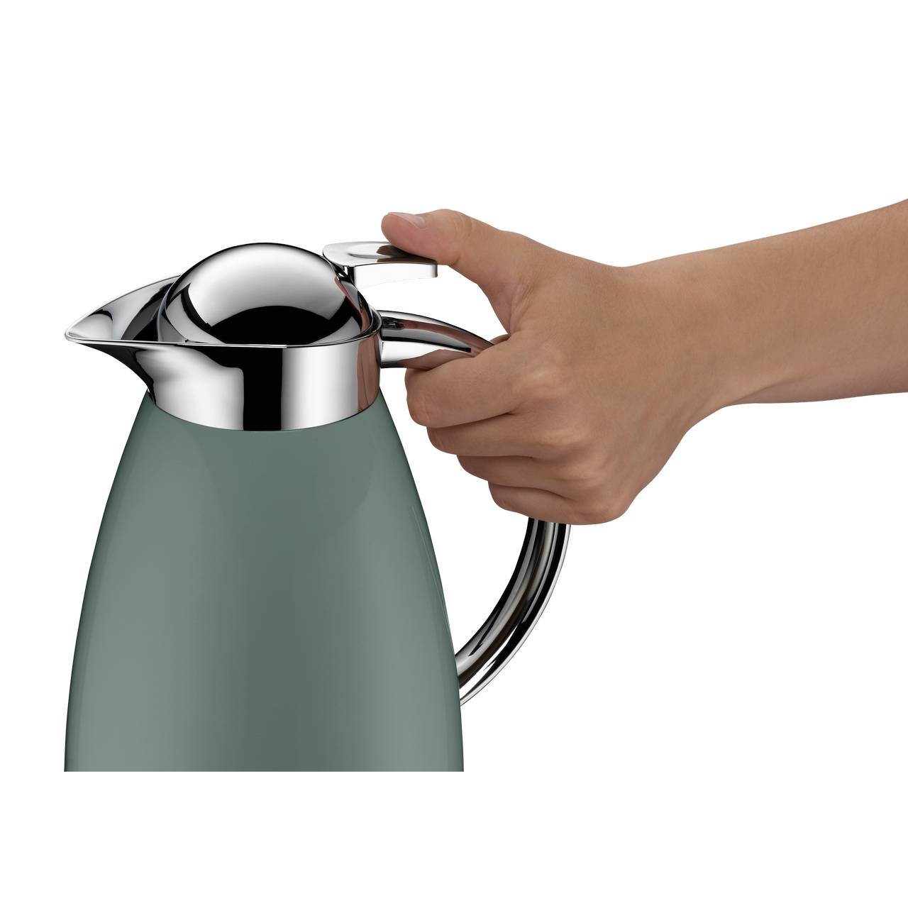 Eine Hand hält eine stilvolle Thermoskanne mit einem glänzenden Chromdeckel und -griff. Der Korpus der Kanne ist in einem matten, graugrünen Farbton gehalten. Die Hand drückt leicht auf einen Hebel am Deckel.