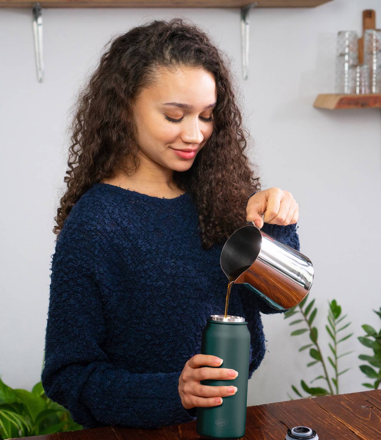woman pouring tea in pure drinking mug kitchen