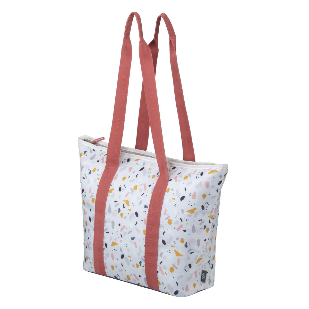 Es ist eine Tasche mit zwei langen, roten Tragegriffen. Der Stoff der Tasche ist weiß mit bunten, unregelmäßigen Mustern in Blau, Gelb, Rosa und anderen Farben. Die Tasche hat einen Reißverschluss an der Oberseite.