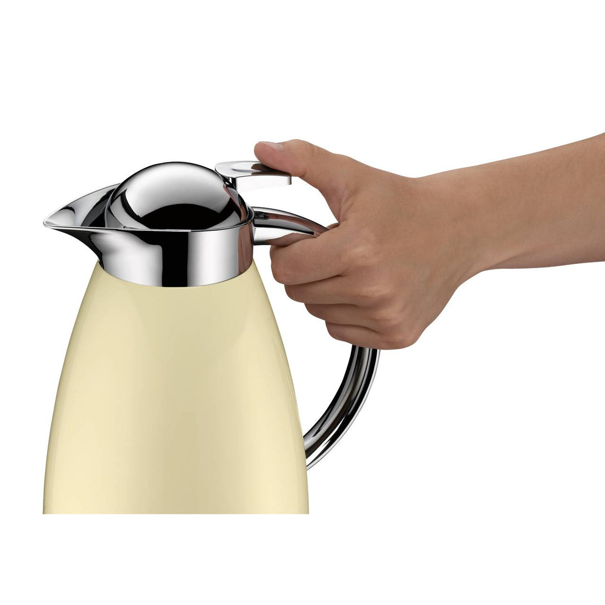 Eine Hand drückt den Verschluss einer cremefarbenen Thermoskanne mit glänzendem, metallischen Deckel. Die Kanne hat einen gebogenen Griff aus Metall.